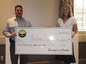 People from Hudson Alpha holding giant check.
